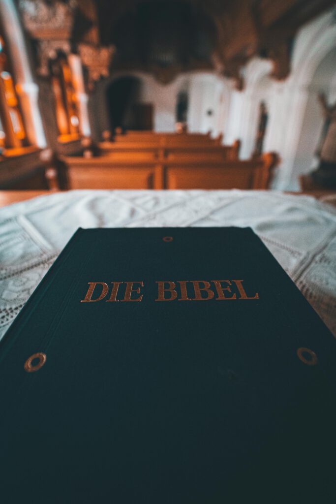 A German Bible on an altar in a church, showing pews in the background.